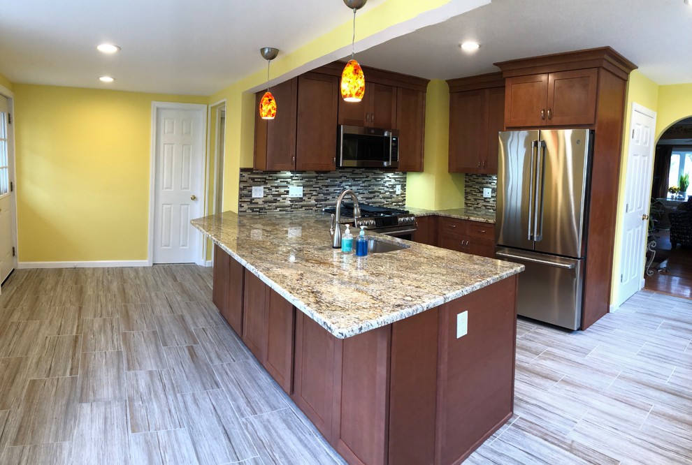 Example of a large eclectic u-shaped porcelain tile and gray floor eat-in kitchen design in Newark with an undermount sink, shaker cabinets, brown cabinets, granite countertops, multicolored backsplash, glass sheet backsplash, stainless steel appliances, no island and multicolored countertops