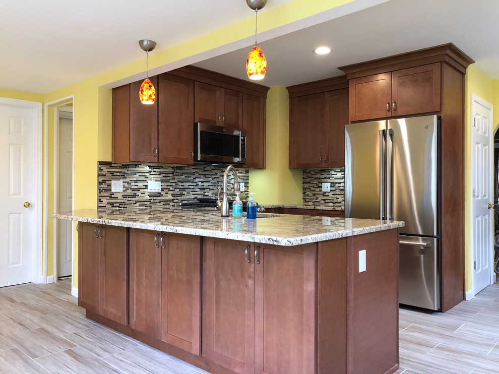 Example of a large eclectic u-shaped porcelain tile and gray floor eat-in kitchen design in New York with an undermount sink, shaker cabinets, brown cabinets, granite countertops, multicolored backsplash, glass sheet backsplash, stainless steel appliances, no island and multicolored countertops