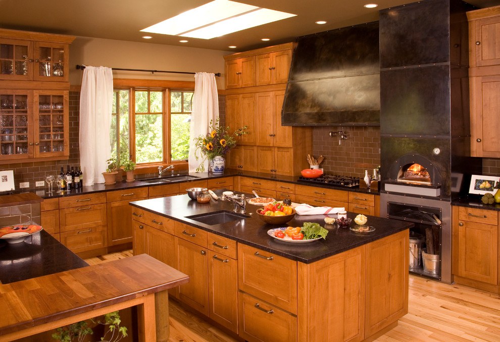 シアトルにあるトラディショナルスタイルのおしゃれなキッチン (シェーカースタイル扉のキャビネット、中間色木目調キャビネット、茶色いキッチンパネル、サブウェイタイルのキッチンパネル) の写真