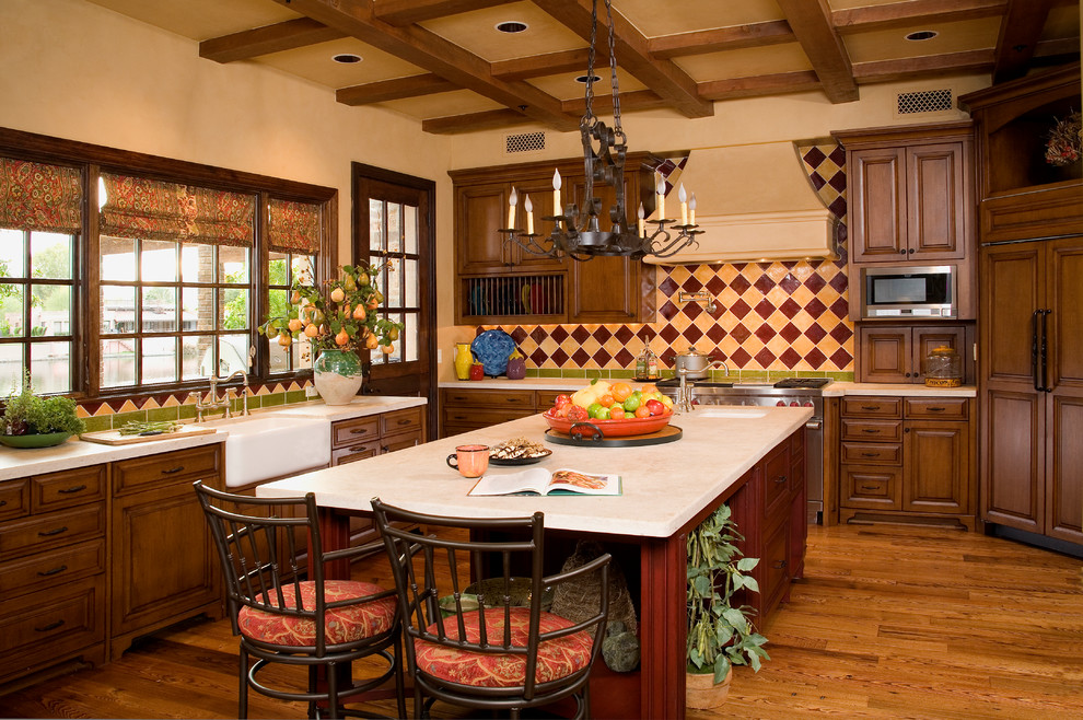 Foto di una cucina chic con lavello stile country, ante con bugna sagomata, ante in legno bruno, paraspruzzi multicolore e elettrodomestici da incasso