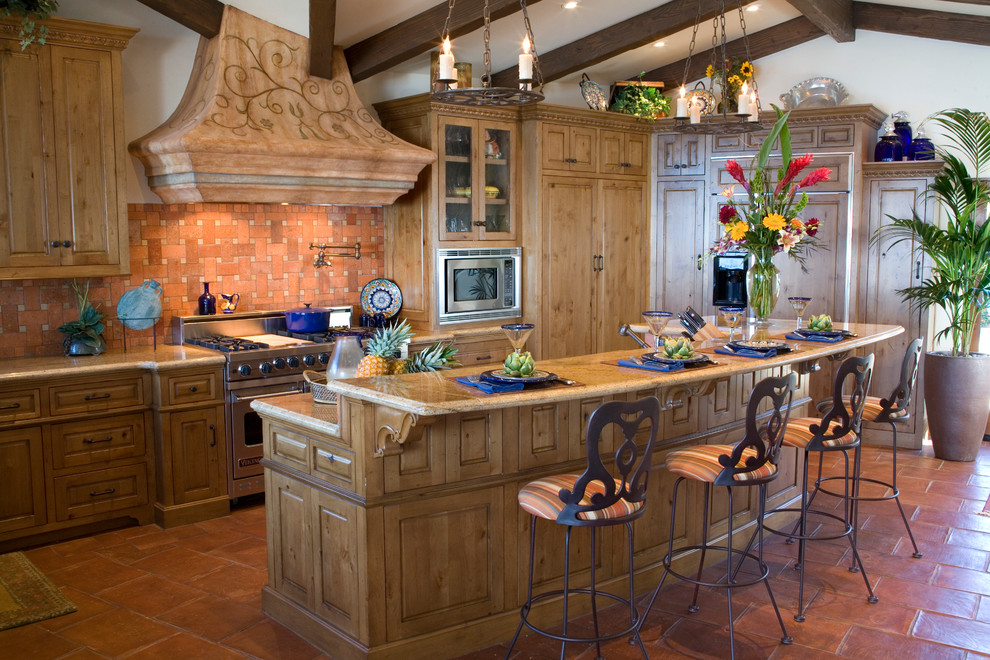 Mid-sized tuscan l-shaped ceramic tile and brown floor eat-in kitchen photo in Orange County with raised-panel cabinets, light wood cabinets, an island, granite countertops, orange backsplash and stainless steel appliances