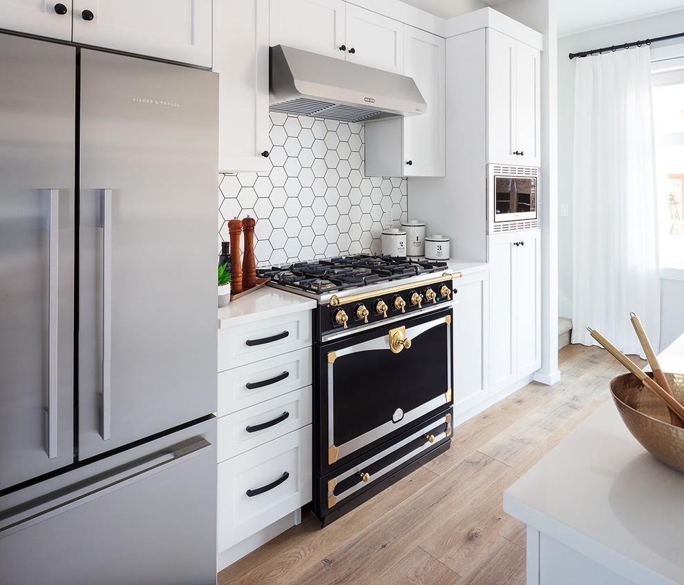 Exempel på ett litet lantligt vit vitt kök, med en undermonterad diskho, skåp i shakerstil, vita skåp, bänkskiva i kvartsit, vitt stänkskydd, stänkskydd i porslinskakel, rostfria vitvaror, laminatgolv och en köksö