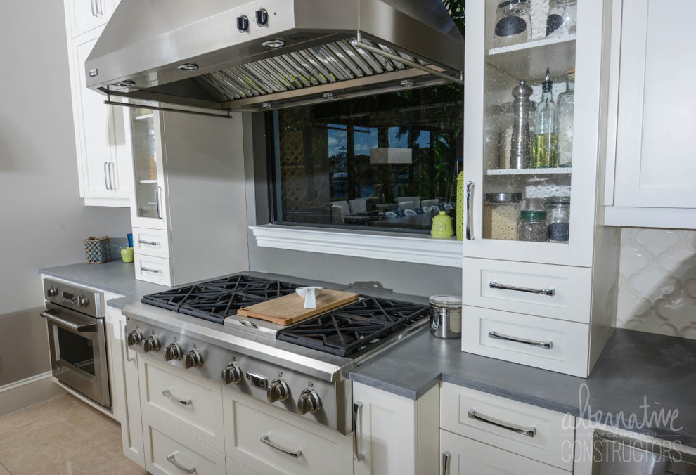 マイアミにあるトロピカルスタイルのおしゃれなキッチン (コンクリートカウンター、シルバーの調理設備) の写真