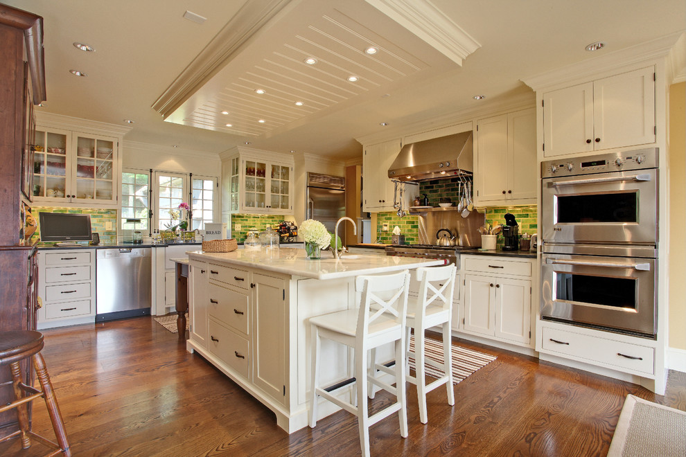 Inspiration for a cottage l-shaped dark wood floor eat-in kitchen remodel in New York with multicolored backsplash, white cabinets, recessed-panel cabinets, stainless steel appliances and marble countertops
