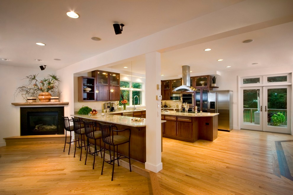 This is an example of a large traditional u-shaped kitchen/diner in Other with a double-bowl sink, dark wood cabinets, granite worktops, stainless steel appliances, medium hardwood flooring and an island.