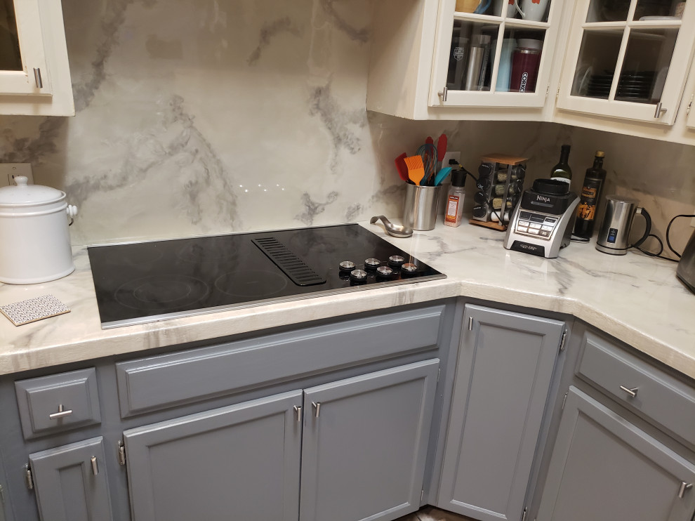 Inspiration for a modern l-shaped kitchen remodel in Austin with recessed-panel cabinets, gray cabinets, white backsplash and white countertops