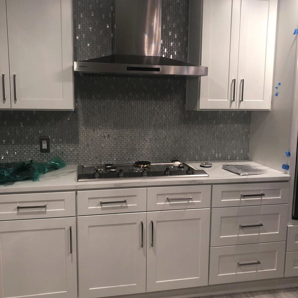 Medium sized modern kitchen/diner in Atlanta with recessed-panel cabinets, white cabinets, engineered stone countertops, stainless steel appliances, multiple islands and white worktops.