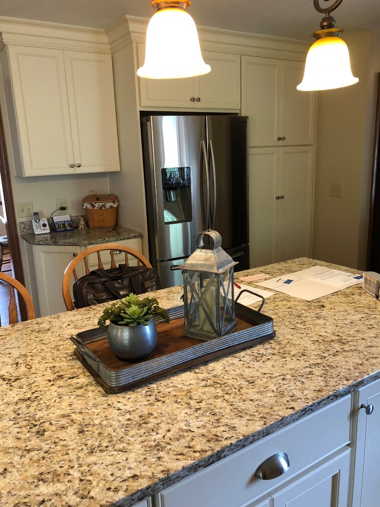 Inspiration for a mid-sized contemporary u-shaped dark wood floor and brown floor kitchen remodel in Cleveland with an undermount sink, beaded inset cabinets, white cabinets, granite countertops, pink backsplash, subway tile backsplash, stainless steel appliances, an island and multicolored countertops