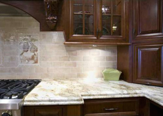 Inspiration for a mediterranean l-shaped kitchen in Cincinnati with raised-panel cabinets, dark wood cabinets, marble worktops, beige splashback, mosaic tiled splashback and stainless steel appliances.