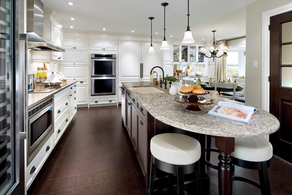Foto på ett stort funkis grå linjärt kök och matrum, med en enkel diskho, vita skåp, bänkskiva i kvarts, flerfärgad stänkskydd, rostfria vitvaror, mörkt trägolv, en köksö och brunt golv