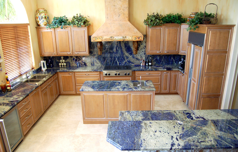 Inspiration för mellanstora eklektiska blått kök, med en undermonterad diskho, luckor med upphöjd panel, skåp i ljust trä, marmorbänkskiva, blått stänkskydd, klinkergolv i keramik, en köksö, integrerade vitvaror, beiget golv och stänkskydd i sten