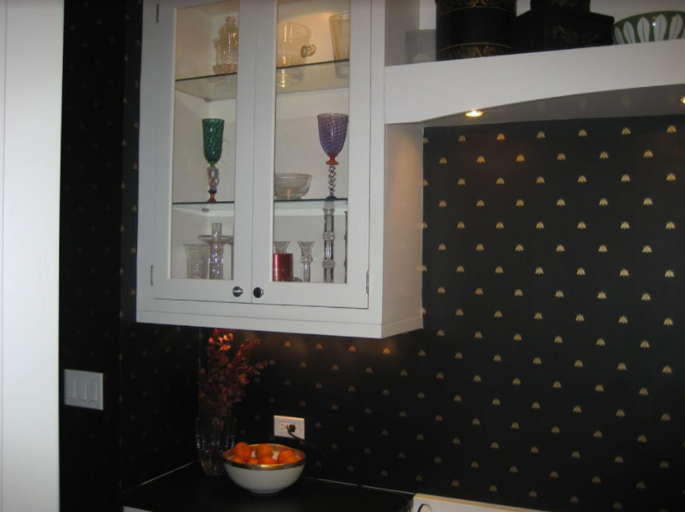 Modelo de cocina clásica con armarios tipo vitrina, puertas de armario blancas, encimera de granito y salpicadero multicolor