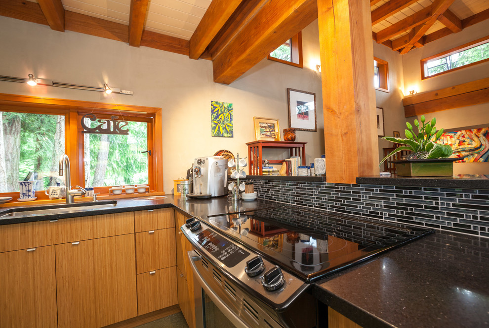 Inspiration for a contemporary l-shaped concrete floor, gray floor and exposed beam kitchen remodel in Other with a single-bowl sink, flat-panel cabinets, medium tone wood cabinets, granite countertops, black backsplash, mosaic tile backsplash, stainless steel appliances, a peninsula and black countertops