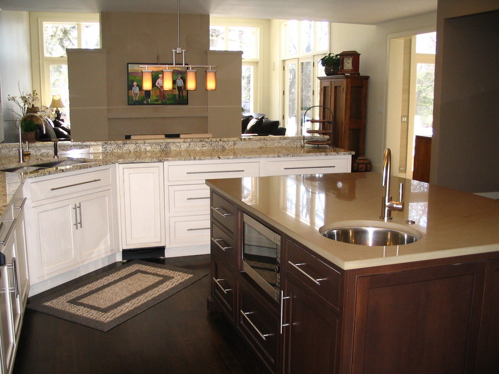 Modelo de cocina comedor clásica con armarios con paneles lisos, puertas de armario blancas y electrodomésticos de acero inoxidable