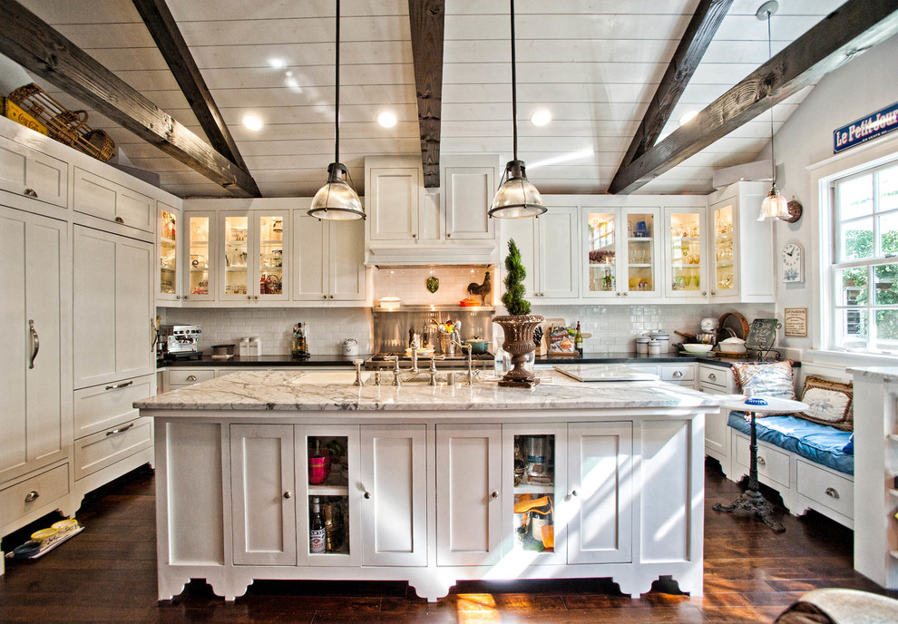 Inspiration for a timeless u-shaped dark wood floor kitchen remodel in Los Angeles with glass-front cabinets, white cabinets, white backsplash, subway tile backsplash and paneled appliances