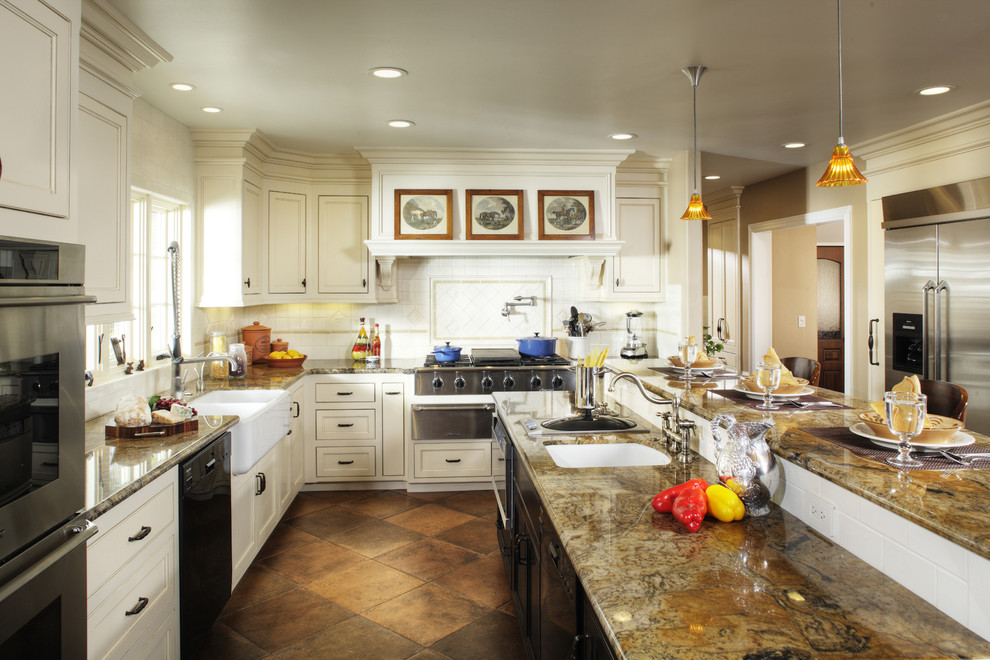 Inredning av ett klassiskt kök, med rostfria vitvaror, en rustik diskho, vita skåp, granitbänkskiva och brunt golv