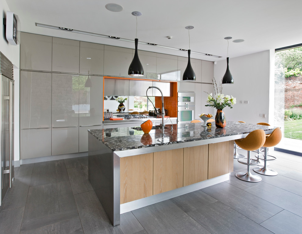 Идея дизайна: угловая кухня в современном стиле с врезной мойкой, плоскими фасадами, серыми фасадами, зеркальным фартуком, техникой из нержавеющей стали и островом