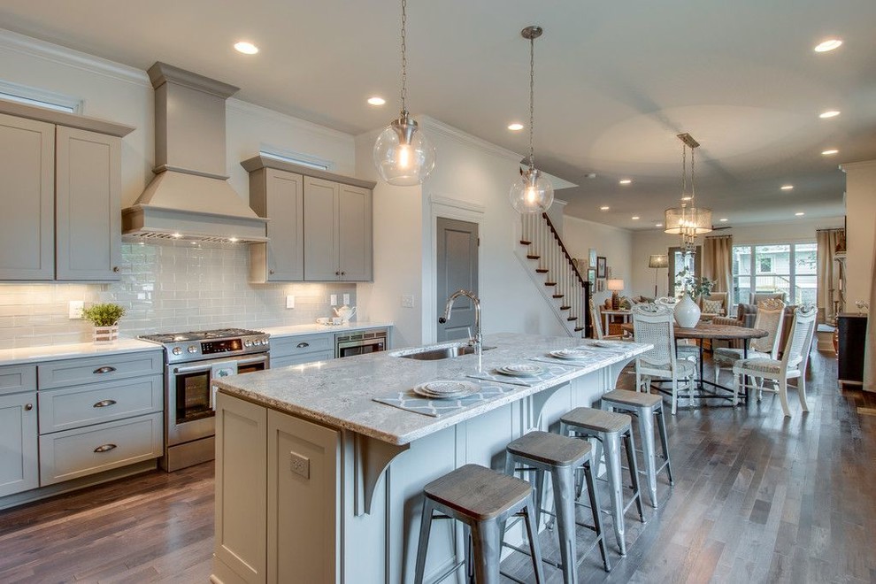Example of a mid-sized trendy single-wall medium tone wood floor kitchen design in Philadelphia with an undermount sink, shaker cabinets, gray cabinets, granite countertops, gray backsplash, ceramic backsplash, stainless steel appliances and an island
