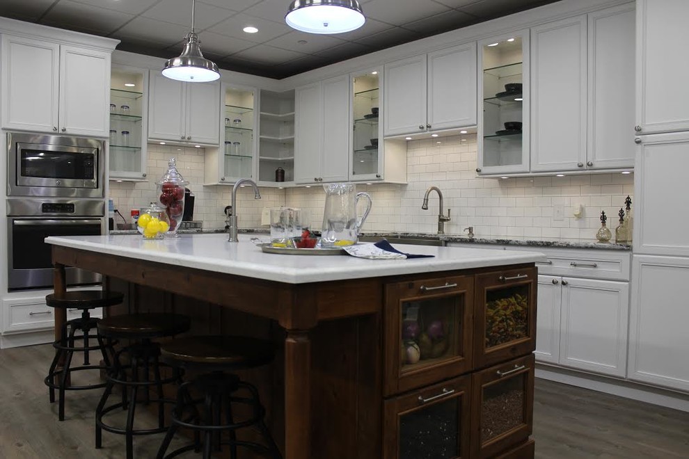 インディアナポリスにある高級な広いトラディショナルスタイルのおしゃれなキッチン (エプロンフロントシンク、ガラス扉のキャビネット、白いキャビネット、大理石カウンター、白いキッチンパネル、石タイルのキッチンパネル、シルバーの調理設備、塗装フローリング、グレーの床) の写真