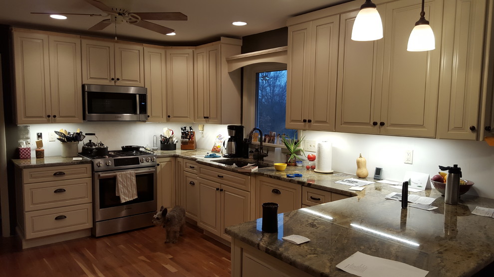Enclosed kitchen - small u-shaped medium tone wood floor enclosed kitchen idea in Other with a single-bowl sink, raised-panel cabinets, beige cabinets, granite countertops, white backsplash, subway tile backsplash, stainless steel appliances and no island