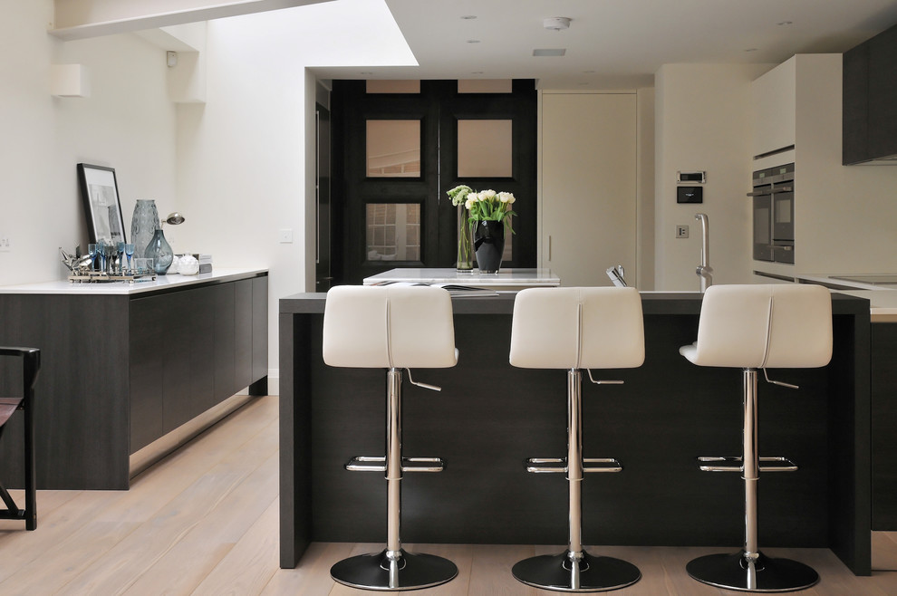 Contemporary kitchen in Gloucestershire with flat-panel cabinets and black cabinets.