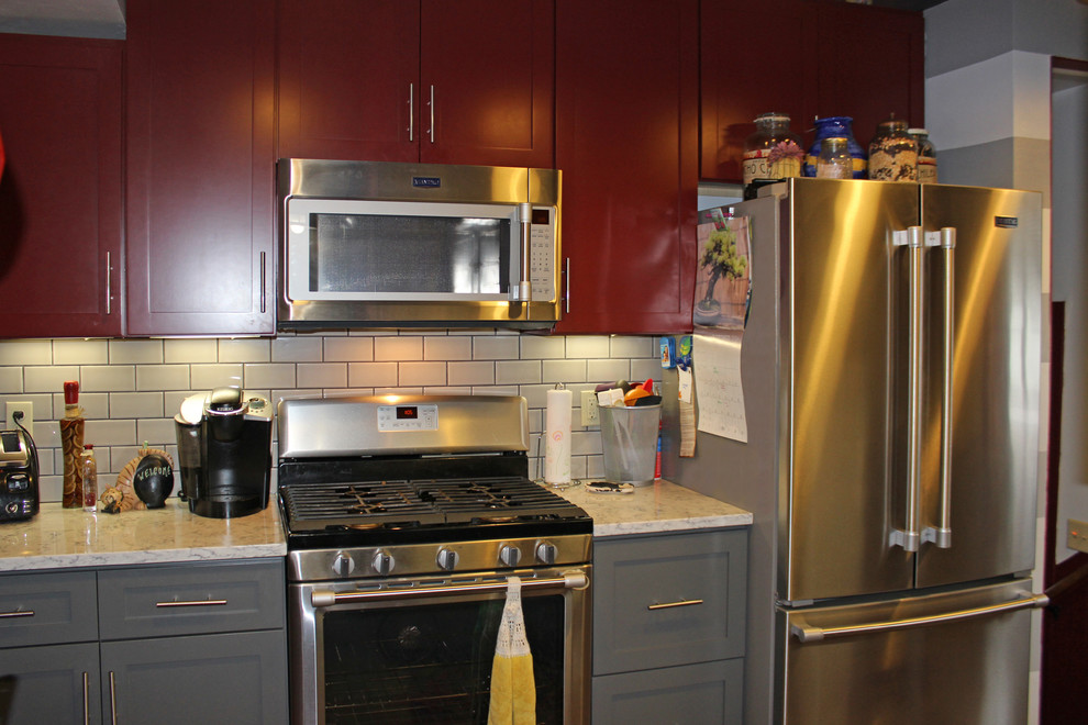 Cette image montre une petite cuisine américaine parallèle craftsman avec un évier de ferme, un plan de travail en quartz, une crédence grise, une crédence en carrelage métro, un électroménager en acier inoxydable et aucun îlot.