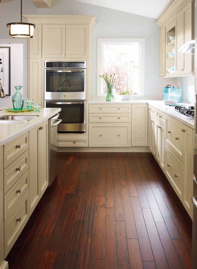 Example of a large transitional u-shaped dark wood floor eat-in kitchen design in Other with an undermount sink, shaker cabinets, beige cabinets, quartz countertops, white backsplash, glass sheet backsplash, stainless steel appliances and an island