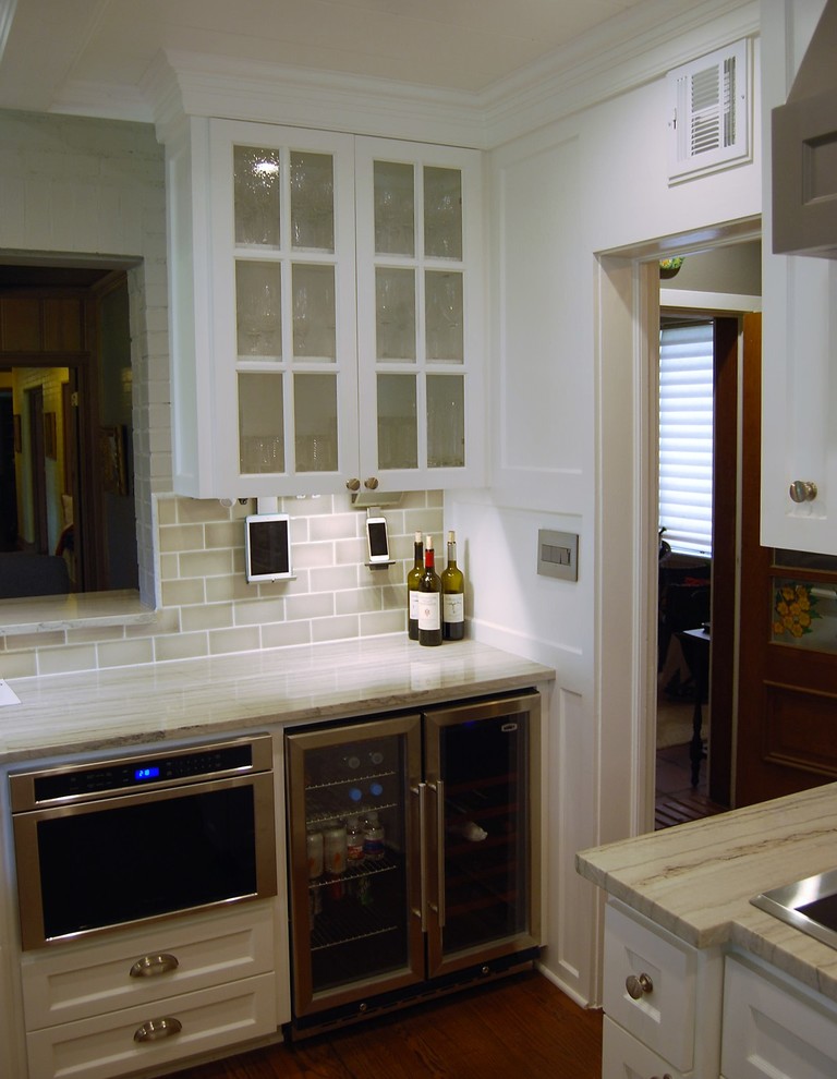 Mid-sized transitional u-shaped light wood floor kitchen photo in Austin with a farmhouse sink, shaker cabinets, white cabinets, quartzite countertops, beige backsplash, porcelain backsplash, stainless steel appliances and an island