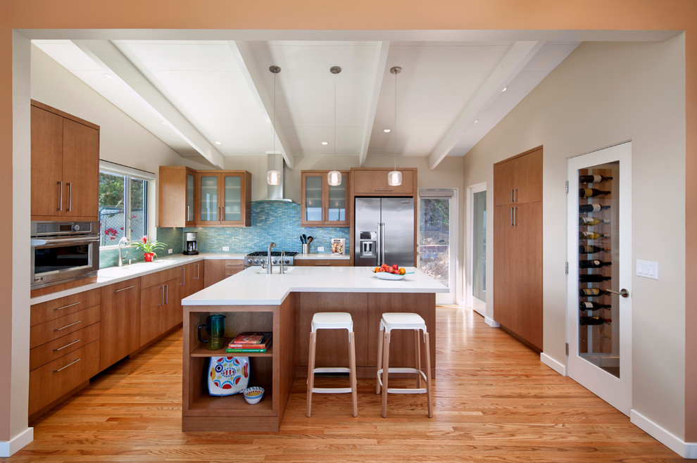 Inspiration for a mid-sized contemporary l-shaped light wood floor and beige floor eat-in kitchen remodel in Santa Barbara with a single-bowl sink, flat-panel cabinets, beige cabinets, quartz countertops, blue backsplash, glass tile backsplash, stainless steel appliances and an island