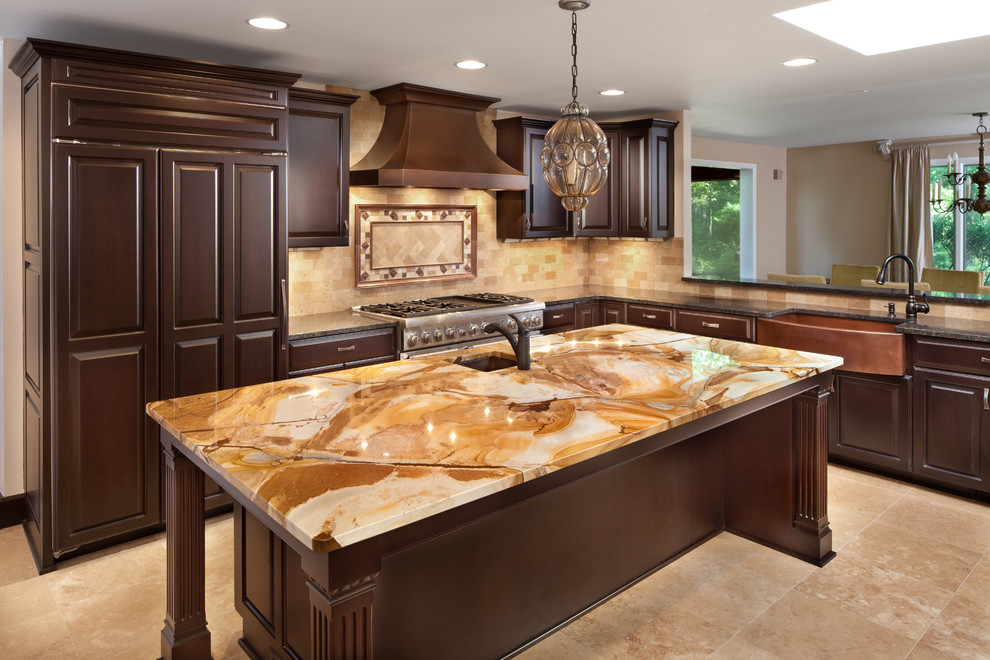 Inspiration for an expansive traditional open plan kitchen in DC Metro with a belfast sink, raised-panel cabinets, dark wood cabinets, onyx worktops, beige splashback, stone tiled splashback, stainless steel appliances, travertine flooring and multiple islands.