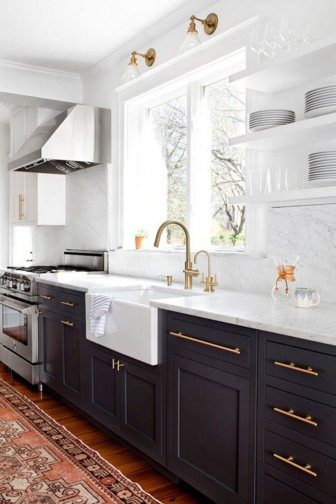 Inspiration for a mid-sized modern single-wall medium tone wood floor and brown floor kitchen remodel in Columbus with a farmhouse sink, flat-panel cabinets, black cabinets, quartz countertops, white backsplash, marble backsplash, stainless steel appliances, two islands and white countertops