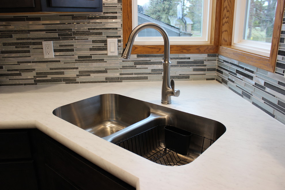 Example of a mid-sized classic u-shaped ceramic tile eat-in kitchen design in Other with an undermount sink, recessed-panel cabinets, dark wood cabinets, laminate countertops, multicolored backsplash, glass tile backsplash, stainless steel appliances, a peninsula and white countertops