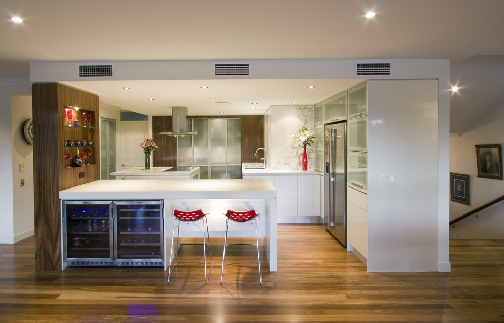 Photo of a contemporary kitchen in Brisbane with stainless steel appliances, glass-front cabinets and white cabinets.