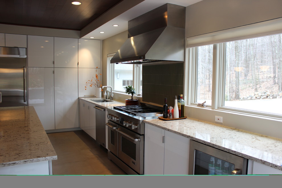 Esempio di una cucina design di medie dimensioni con lavello sottopiano, ante lisce, ante bianche, top in granito, paraspruzzi a finestra, elettrodomestici in acciaio inossidabile e pavimento marrone
