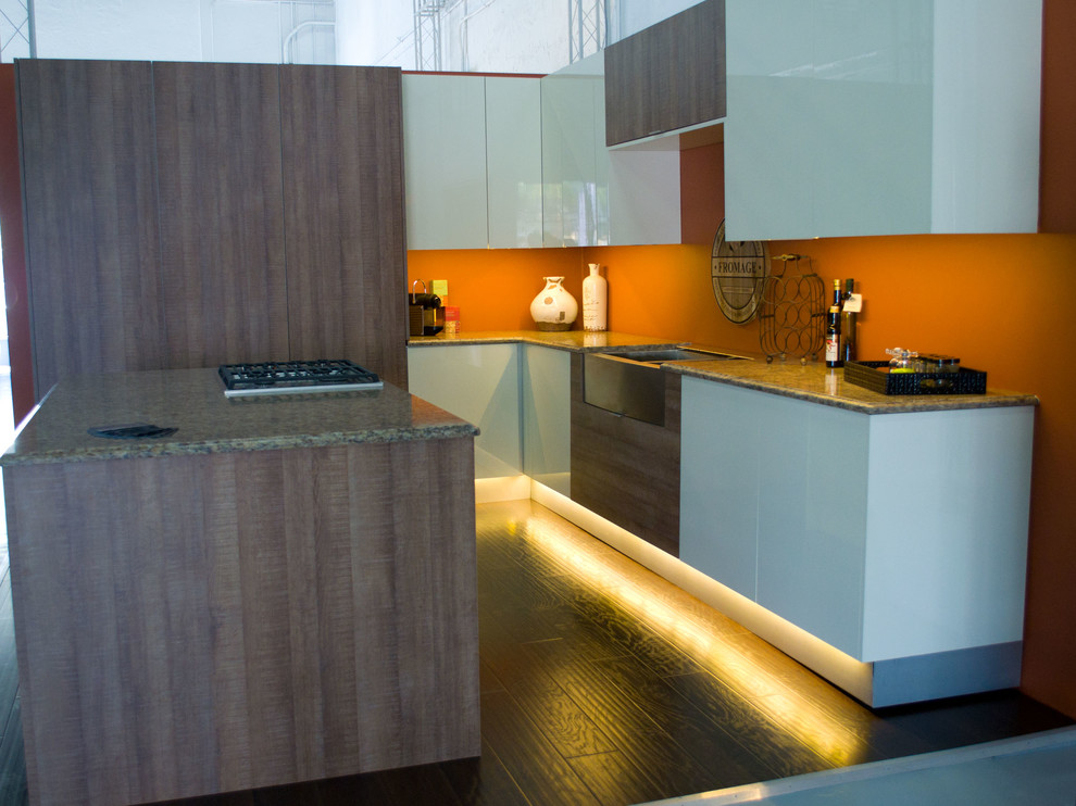 Bild på ett avskilt, mellanstort funkis l-kök, med en undermonterad diskho, granitbänkskiva, orange stänkskydd, integrerade vitvaror, mörkt trägolv och en köksö