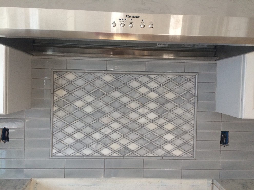 Foto di una cucina minimal con ante bianche, top in marmo, paraspruzzi grigio, paraspruzzi con piastrelle in ceramica e elettrodomestici in acciaio inossidabile