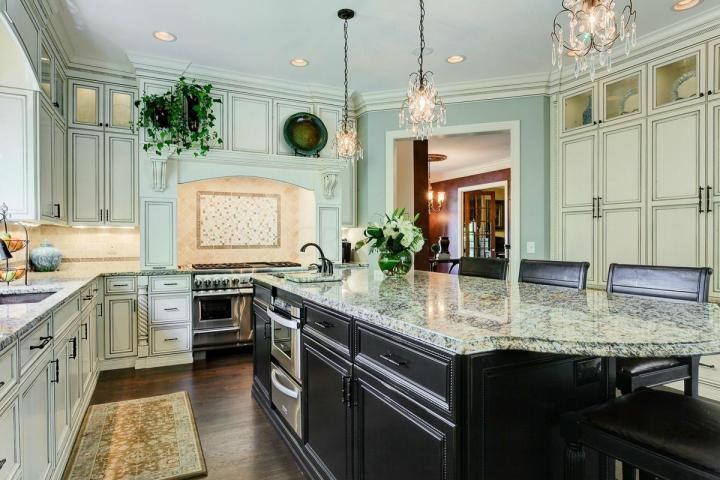 Classic single-wall open plan kitchen in Columbus with a built-in sink, beaded cabinets, white cabinets, granite worktops, stainless steel appliances, medium hardwood flooring and an island.
