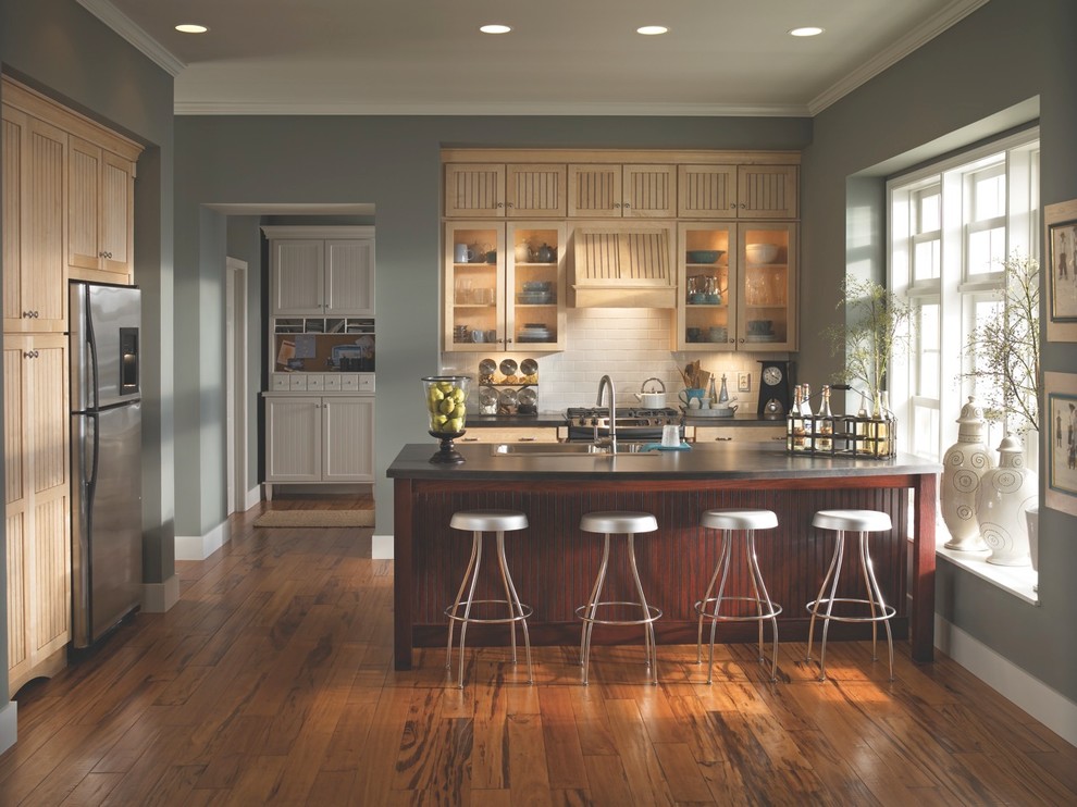 Kleine Moderne Küche in L-Form mit Einbauwaschbecken, hellen Holzschränken, Küchengeräten aus Edelstahl, braunem Holzboden und Kücheninsel in Cincinnati