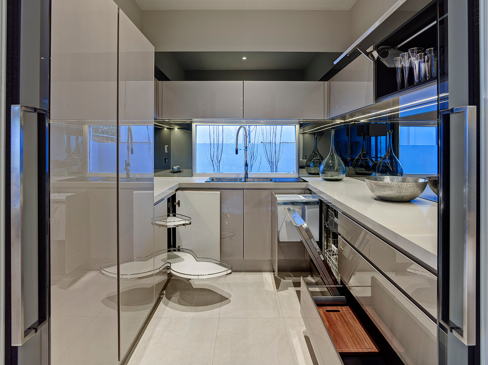 Inspiration för ett litet funkis u-kök, med en dubbel diskho, släta luckor, grå skåp, stänkskydd med metallisk yta, spegel som stänkskydd och integrerade vitvaror
