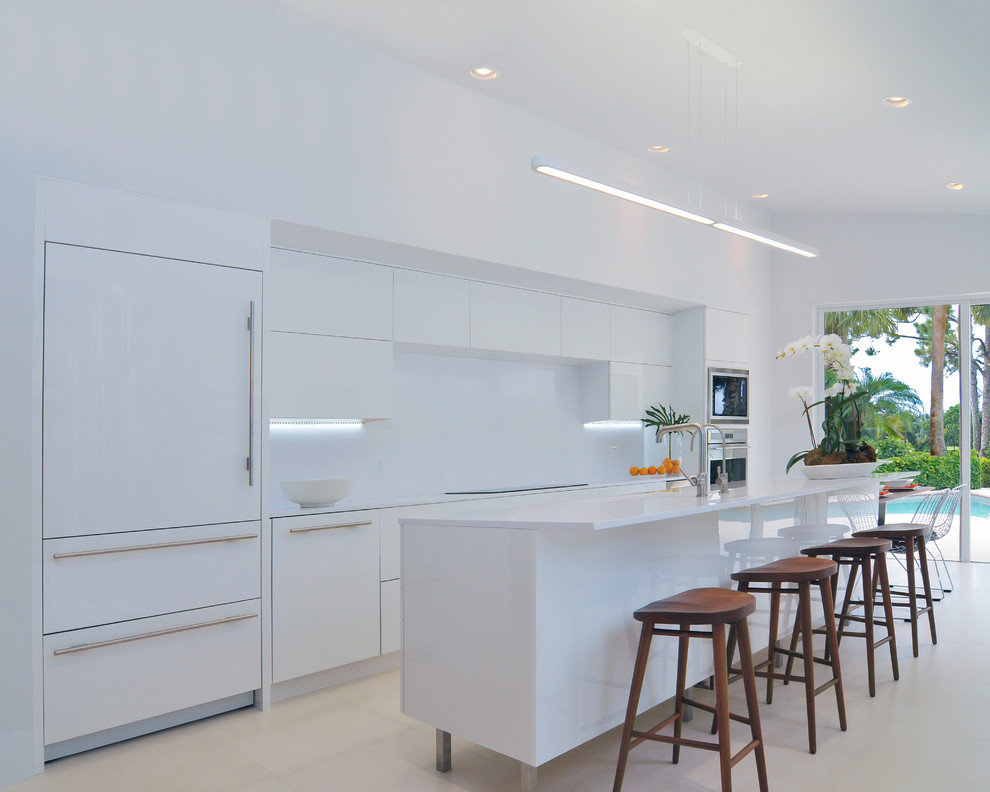 Einzeilige Moderne Küche mit flächenbündigen Schrankfronten, weißen Schränken, Küchenrückwand in Weiß, Elektrogeräten mit Frontblende und Kücheninsel in Sonstige