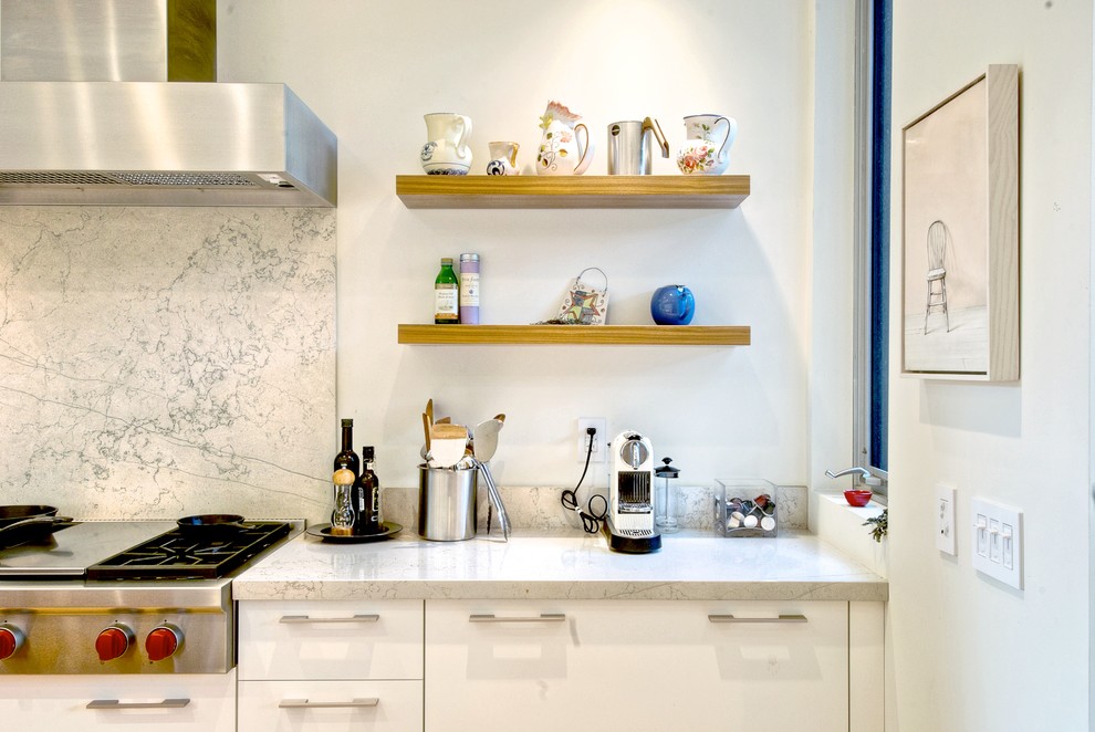 Imagen de cocina minimalista con armarios con paneles lisos, puertas de armario blancas, encimera de mármol, salpicadero blanco y salpicadero de losas de piedra