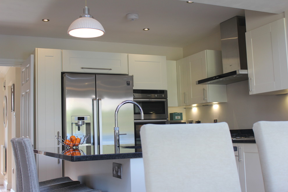 Medium sized rural l-shaped kitchen/diner in Hertfordshire with a submerged sink, shaker cabinets, beige cabinets, granite worktops, stainless steel appliances and an island.