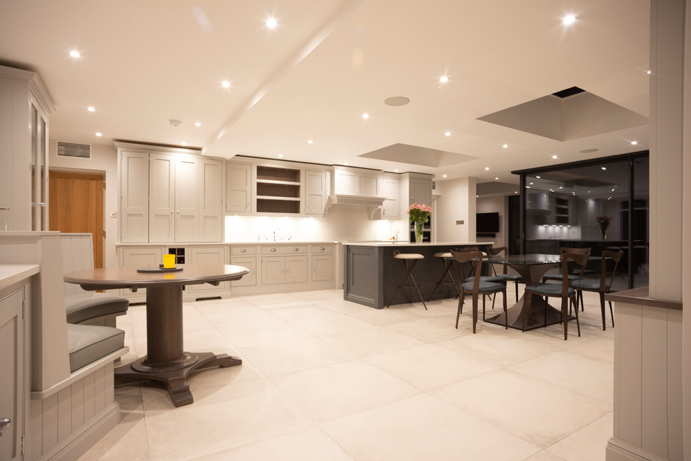 Example of a large trendy white floor eat-in kitchen design in Surrey with marble countertops, an island and white countertops