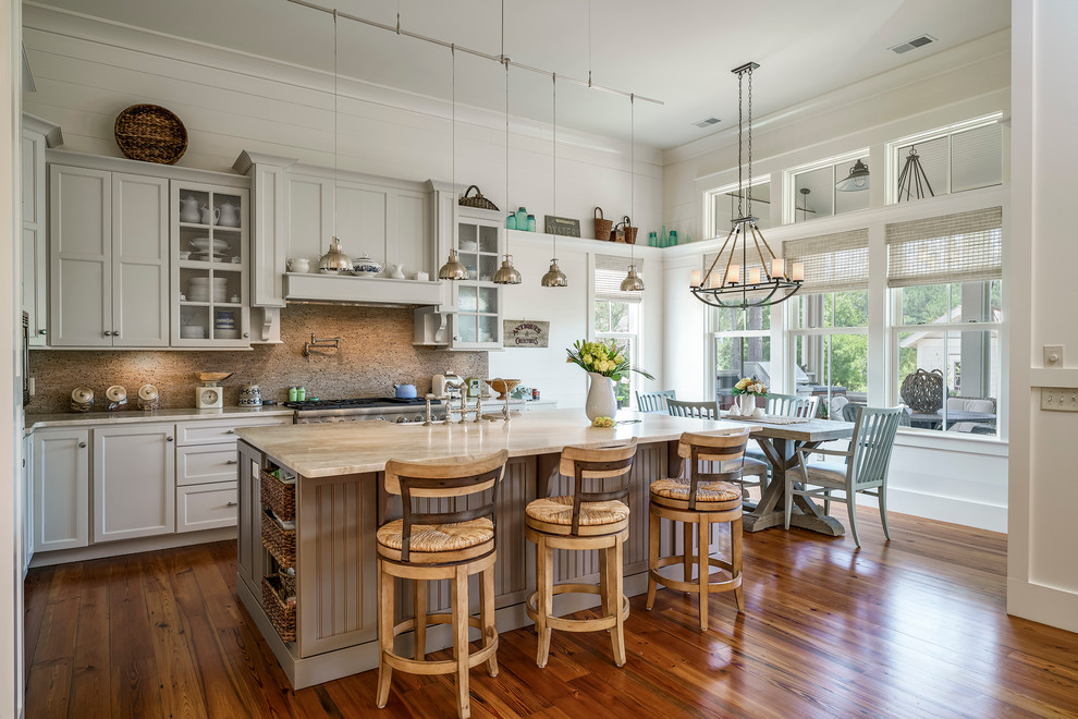 Klassische Wohnküche mit Schrankfronten im Shaker-Stil, Küchengeräten aus Edelstahl, braunem Holzboden, Kücheninsel, grauen Schränken, Marmor-Arbeitsplatte, Küchenrückwand in Beige und Einbauwaschbecken in Charleston