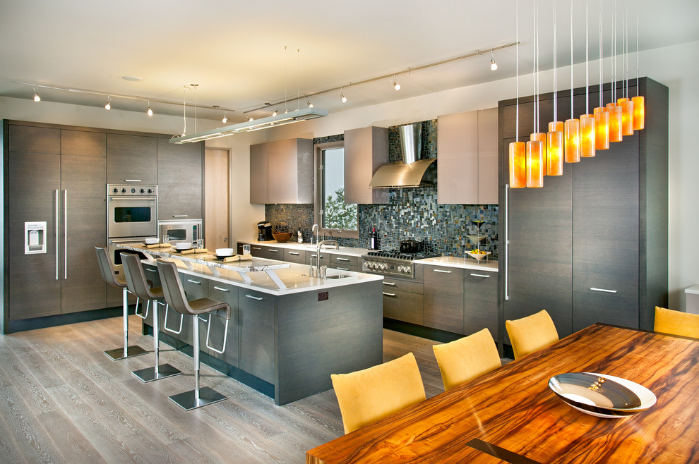 Esempio di una cucina design di medie dimensioni con lavello sottopiano, ante lisce, ante in legno chiaro, paraspruzzi con piastrelle di vetro, elettrodomestici in acciaio inossidabile e parquet chiaro