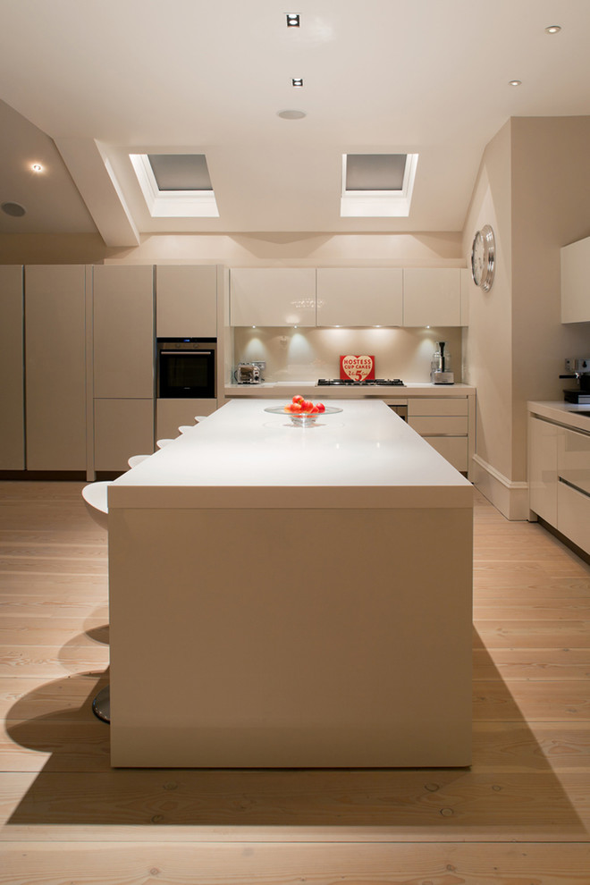 Imagen de cocina comedor contemporánea con puertas de armario de madera en tonos medios, encimera de mármol y una isla
