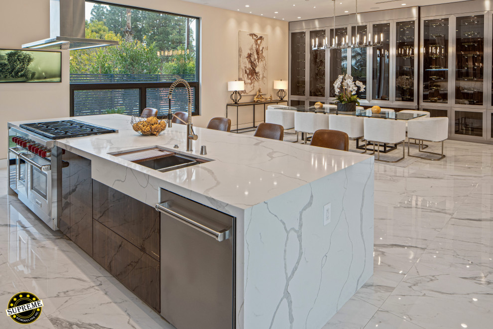 Inspiration for a large modern single-wall marble floor and white floor open concept kitchen remodel in Los Angeles with an undermount sink, flat-panel cabinets, dark wood cabinets, marble countertops, white backsplash, marble backsplash, stainless steel appliances, an island and white countertops