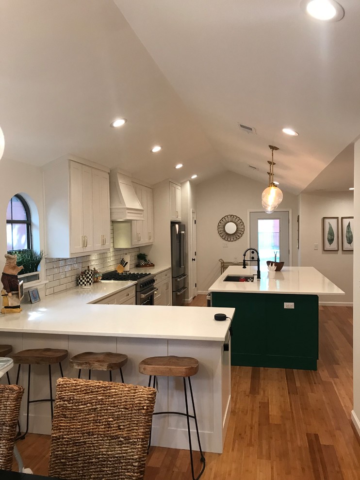Foto på ett stort vintage vit linjärt kök och matrum, med en undermonterad diskho, skåp i shakerstil, vita skåp, bänkskiva i kvartsit, vitt stänkskydd, stänkskydd i keramik, rostfria vitvaror, bambugolv, en köksö och brunt golv