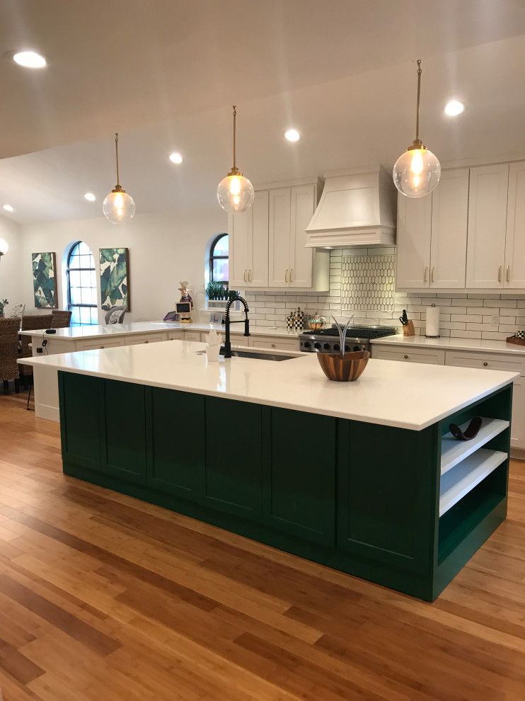 Photo of a large classic single-wall kitchen/diner in Dallas with a submerged sink, shaker cabinets, white cabinets, quartz worktops, white splashback, metro tiled splashback, stainless steel appliances, light hardwood flooring, an island, yellow floors and white worktops.