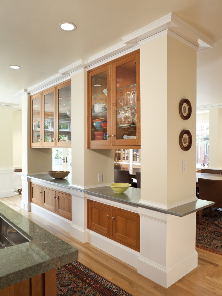 Elegant kitchen photo in San Francisco with glass-front cabinets and medium tone wood cabinets